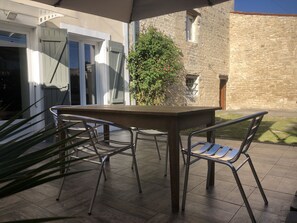 Terrasse avec cour intérieure. table et chaises de jardin.