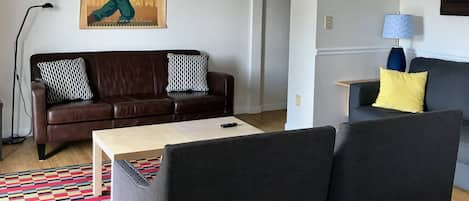 Comfy living room with cathedral ceiling and sliding door to deck.