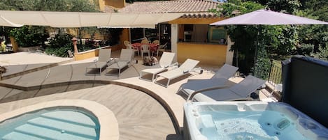 Vaste terrasse avec ombre et soleil autour de la piscine et du Spa