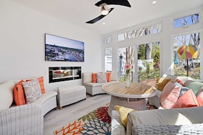 Sunroom with 64in tv & electric fireplace. Opens up to the flower garden & pool