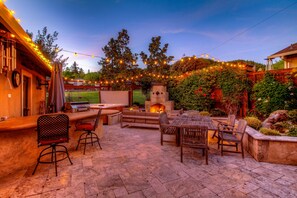 Outdoor kitchen and eating area, with water feature nearby