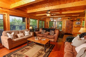 Living room with recliners, sleeper sofa, and wood burning fireplace.