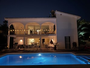 House from pool at night