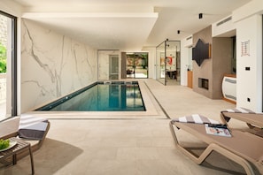 Sonnenliegen am privaten Innenpool im Familienferienhaus Thalia mit Fitnessstudio in Marina