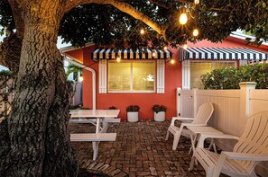 Porch at night with Edison bulb tree lights on. Looking toward kitchen window.