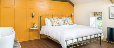 Panelled bedroom with Super King size bed and free-standing bath