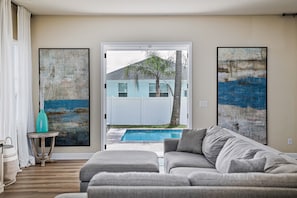 Living room opening to the backyard with heated pool