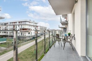 A balcony with wooden railings, offering a view of the surrounding area and modern buildings.