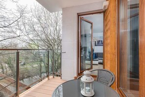 A different angle of the balcony with an inviting setup for relaxation and views of the surrounding nature.