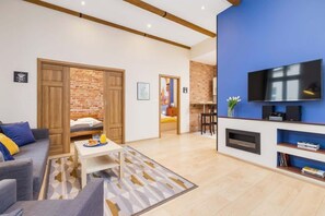 Another view of a living room with exposed wooden beams on the ceiling and modern furnishings.
