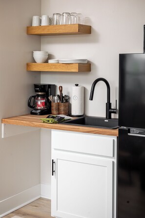 Designed for your comfort, this kitchen area features a sink, small appliances, and open shelving to make your stay as convenient as possible.