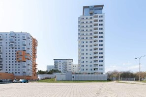 A view of a tall apartment building, showcasing its modern design and surroundings