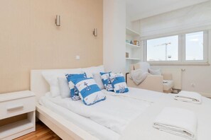 A bedroom with a neatly made bed, light-colored decor, and a calming ambiance.