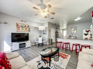 Open-plan living and dining area featuring modern furnishings and Disney accents