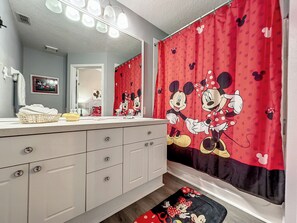 Playful Mickey-themed bathroom with vibrant decor and ample space.