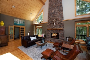 Large living area with wood burning fireplace and vaulted ceilings.