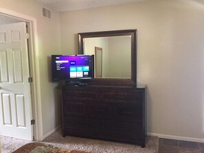 HDTV with cable, Roku, or DVD options atop an oversized dresser in bedroom.