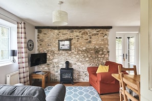 The living room with log burner at Harcombe Cottage, Devon