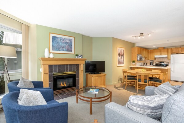 Open-plan living area featuring a gas fireplace, TV, and comfy seating