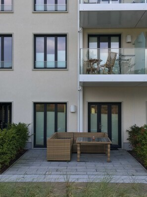 Hausrückseite: Terrasse mit Sitzecke und  Balkon mit seitlichem Meerblick