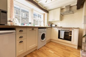 Kitchen area with plenty of worktop space complete with dishwasher and washing machine