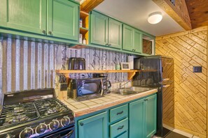 Retro style kitchen fully stocked with all cookware, dishes, and basic cooking spices.
