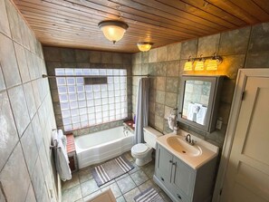 The tile and wood decor will enchant while you soak in this vintage bathtub.