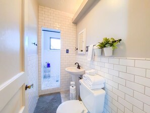 The modern feel of this tiled lavatory is complimented by the lighting.