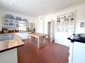 The kitchen. The traditional red floor tiles are regularly polished.