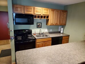 Kitchen with granite countertops, microwave, dishwasher, stove & fridge