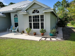 Front patio with seating area and walk around sidewalk to pool area & back yard.