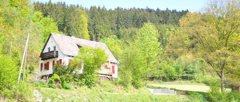 Unser Häuschen am Nierbach, umgeben von Wald und Wiese.