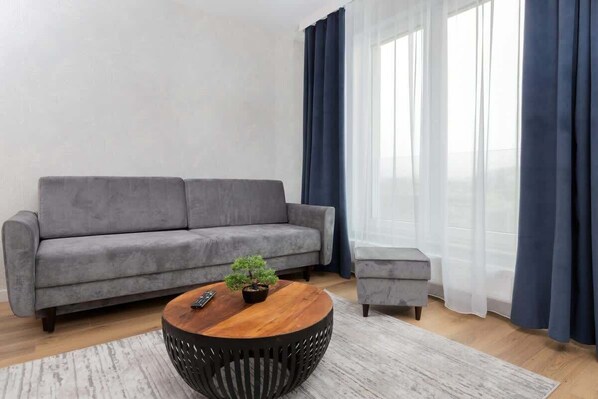 The living room features a sleek coffee table and a flat-screen television.