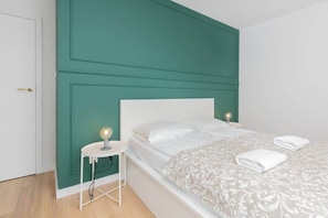 Bedroom with stylish white coffee table and comfortable double bed.