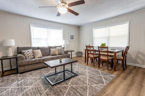 Living room with sleeper sofa and dining table that seats 6.