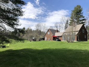 The house with grill, hot tub and outdoor dining area visible. 