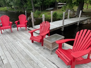 Seating on dock by waterfront with kayaks & canoe