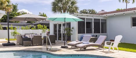 Private backyard with pool and comfortable seating.