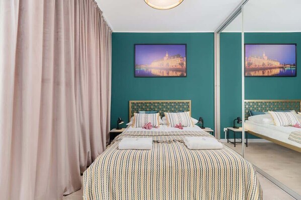 The vibrant living area adorned with noble green and gold hues featuring a double bed.