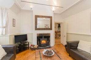 The living room with wood burner and vaulted ceiling.