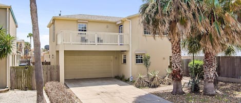 Front of the house. 2 stories with a garage, paved driveway, and balcony. 