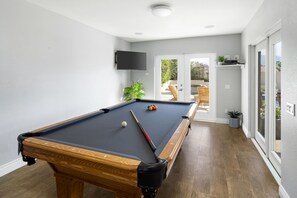 The game room is outdoor adjacent and fully equipped for entertaining. 