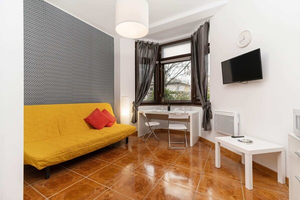 The vibrant living area adorned with bright yellow hues featuring a double sofa bed.