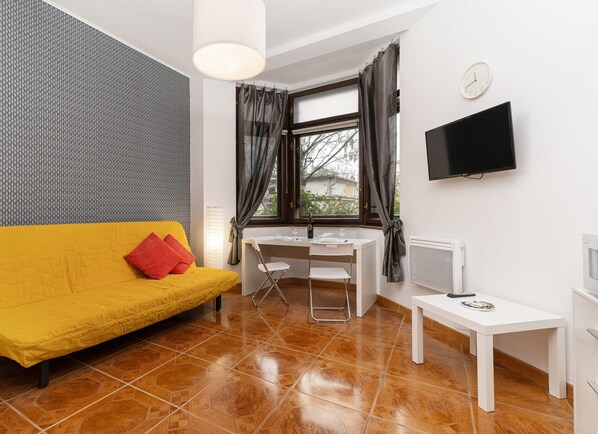 The vibrant living area adorned with bright yellow hues featuring a double sofa bed.