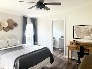 Spacious master suite with cotton sheets, blackout curtains, desk, ceiling fan