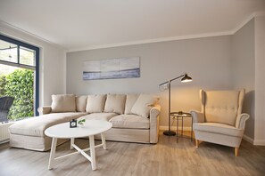 Wohnzimmer mit Ecksofa und Sessel