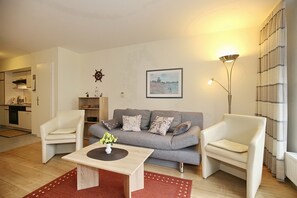 Wohnzimmer mit Schlafcouch und Sesseln