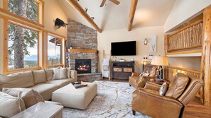 Luxurious open concept living room with gas fireplace, HDTV with streaming capabilities, and unparalleled alpine views of Whitefish Mountain Resort