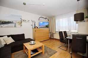 Wohnzimmer mit Schlafcouch und Essbereich