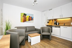 Wohnzimmer mit Sofa und Küchenzeile